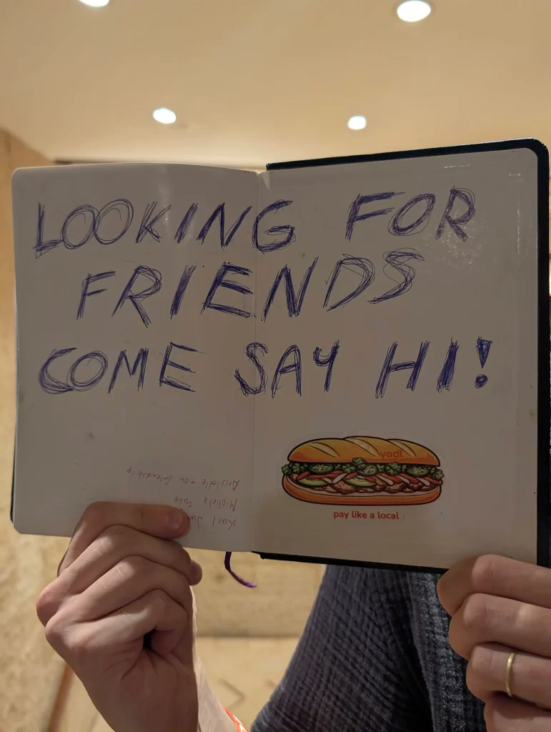 直球對決看板：這招聽起來很瘋　但真的超有用！就像我們去看歐巴演唱會一定會舉應援牌一樣，直接在筆記本或板子上寫大大的「Come say hi!」。相信我，大家看到這種直白的熱情，都會忍不住過來跟你聊兩句的。 